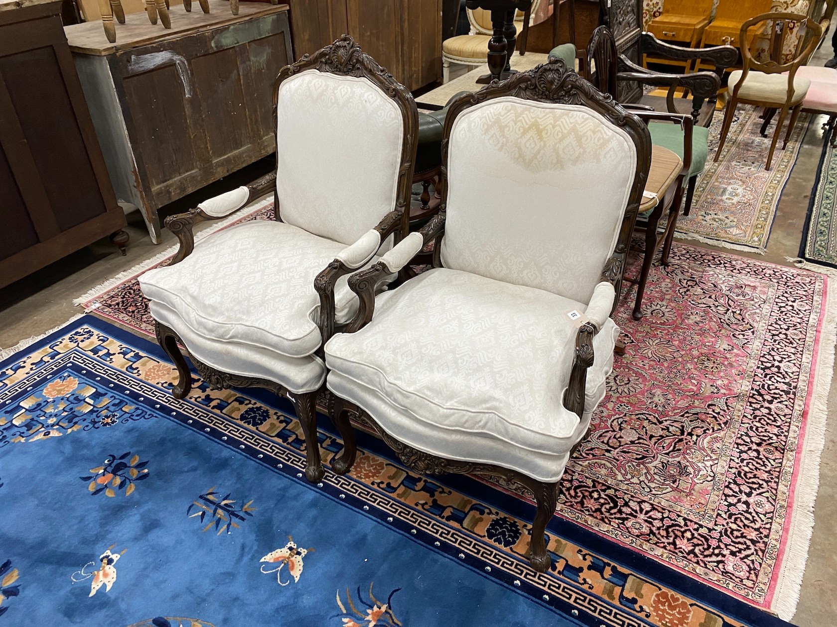 A pair of Louis XVI style carved walnut armchairs, width 67cm, height 113cm